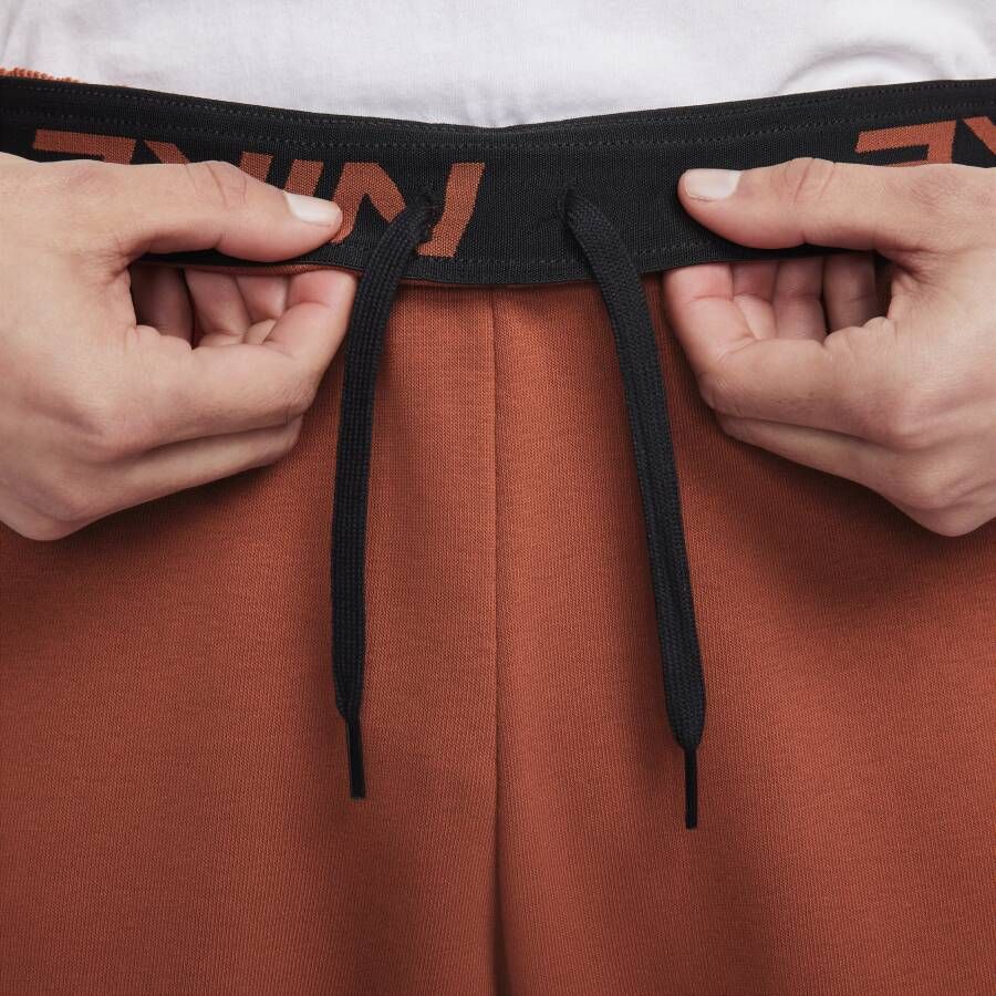 Nike Dry Dri-FIT toelopende fitnessbroek van fleece voor heren Oranje