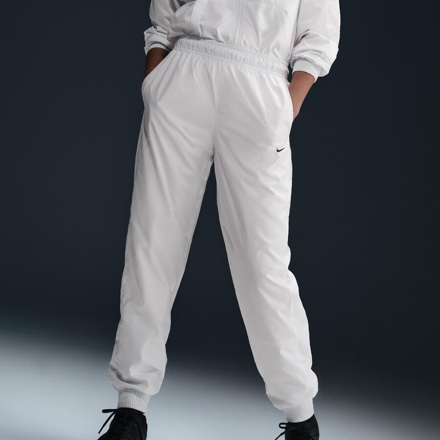 Nike Classic Wovens ruimvallende joggingbroek met uv-bescherming en halfhoge taille voor dames Wit