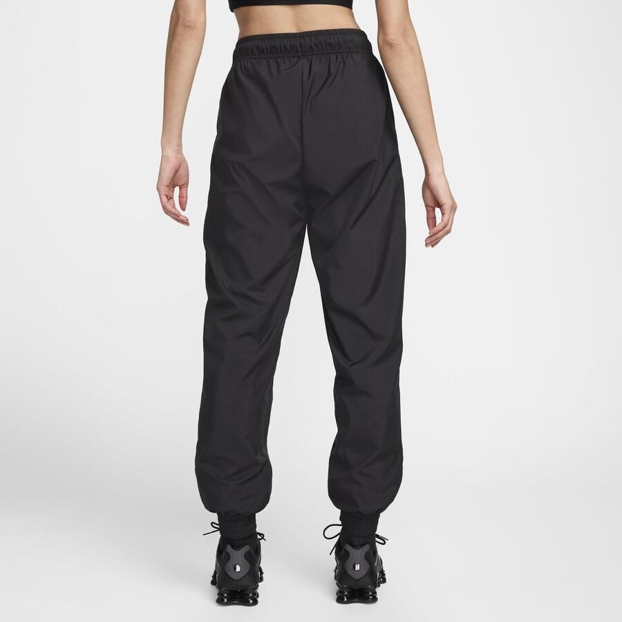Nike Classic Wovens ruimvallende joggingbroek met uv-bescherming en halfhoge taille voor dames Zwart
