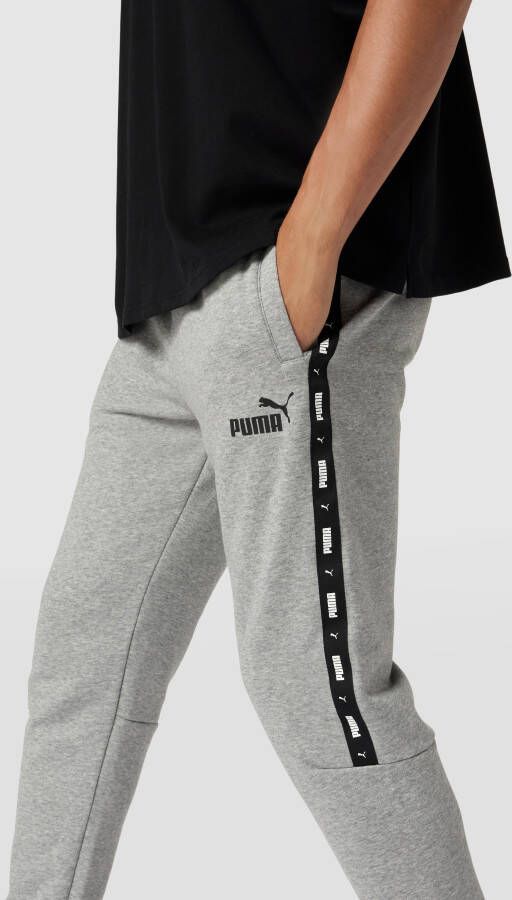 PUMA PERFORMANCE Sweatpants met labeldetail model 'ESS+ Tape Sweatpants'